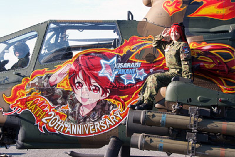 Helicopter gunship with anime side art, and a young woman who looks like the anime character is sitting on the main weapons. Helicopter gunship with anime side art, and a young woman who looks like the anime character is sitting on the main weapons.