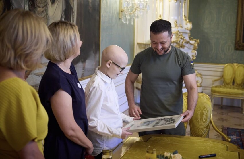 Zelenskyy meets Ukrainian boy Anton Kotso and is actually smiling.