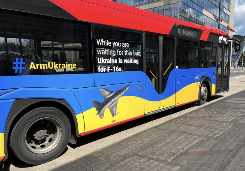 Lithuanian bus with side art saying 'While you are waiting for this bus, Ukraine is waiting for F-16s.