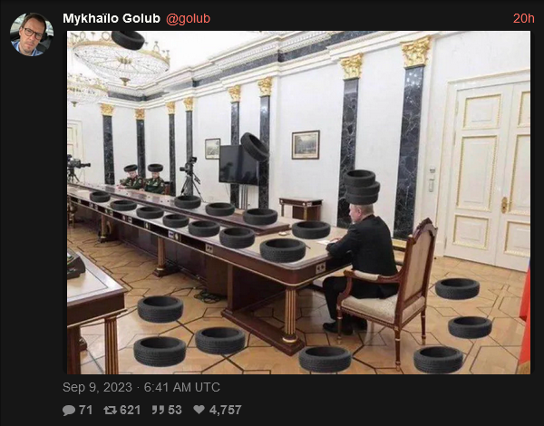 Putin at a long conference table, with tires shopped in.
