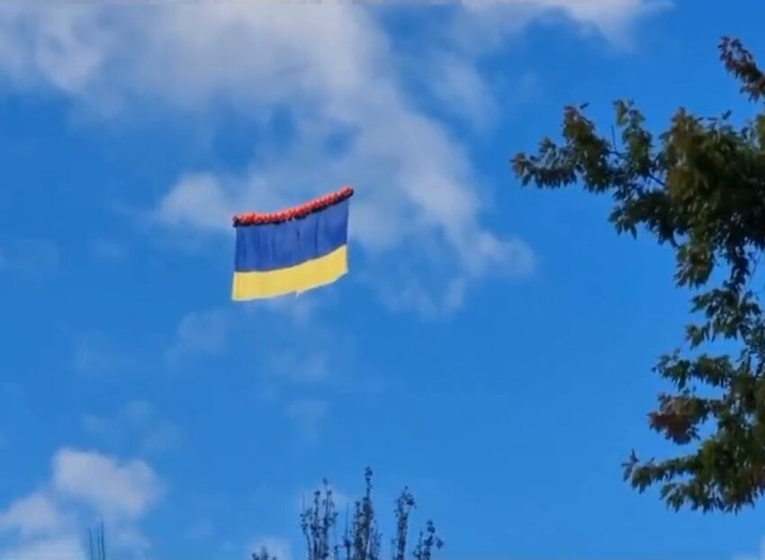 Ukrainian flag with balloons attached flying at low altitude. Russians fired at it, revealing their positions.