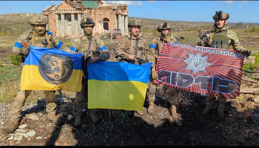 Ukrainian army with flags saying they have liberated Klishchiivka.