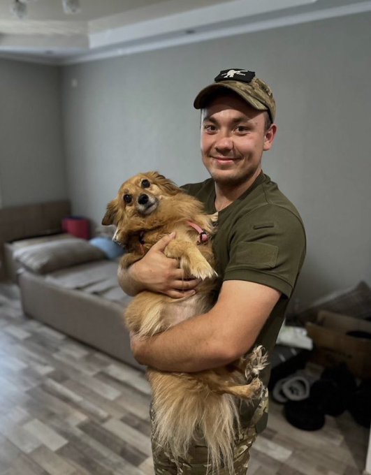 A Ukrainian soldier with a small dog.