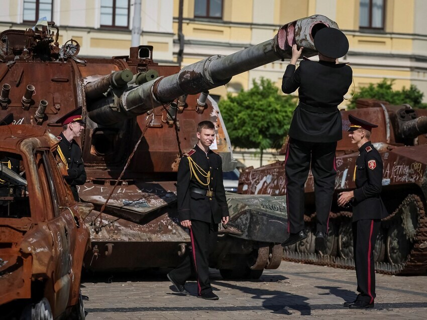 Russian hanging on a tank's main gun barrel and looking into it.