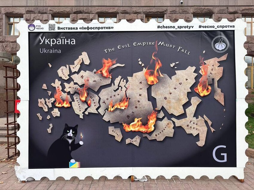 Large poster showing Russia broken up into a bunch of smaller nations, with a cat setting these nations on fire.
