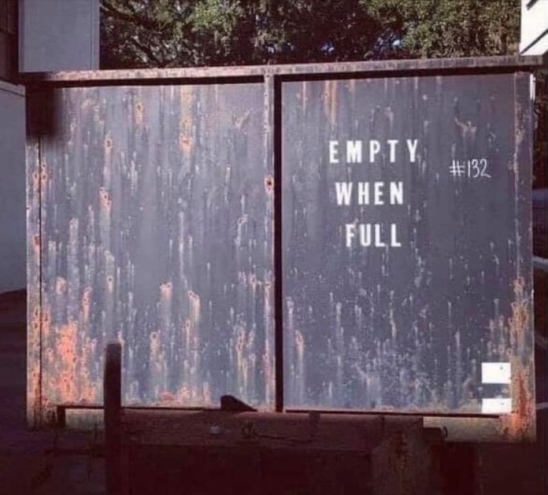 Large metal dumpster labeled 'Empty when full'