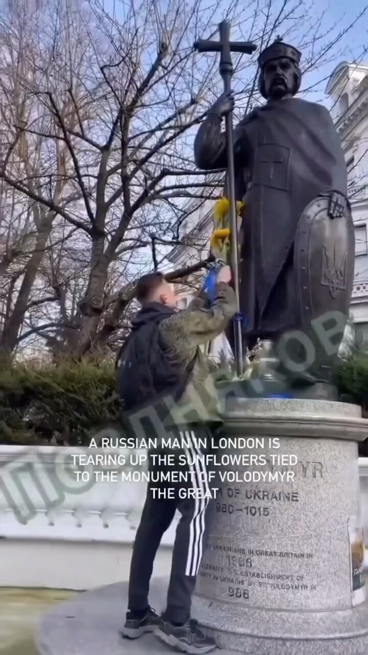 Russian removes sunflowers from a monument to Volodymyr the Great.