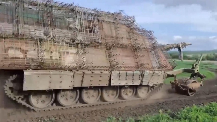 A Russian tank called a 'turtle tank', with many cope cages all over it.