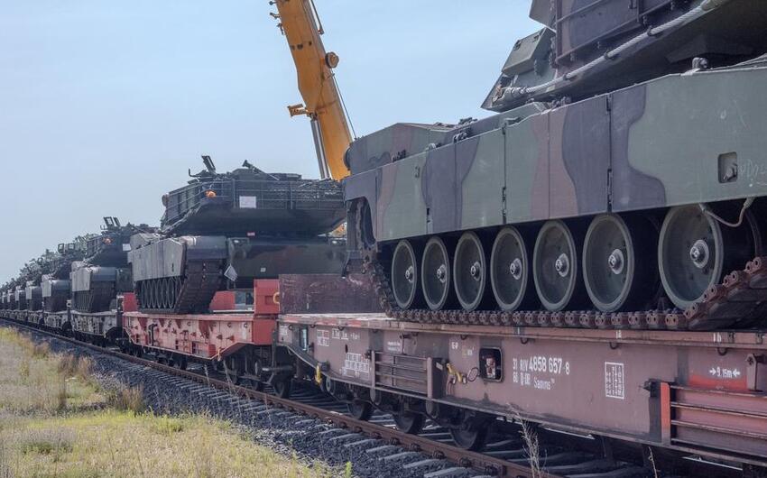 A train full of M1 Abrams tanks transports them into a NATO facility in Poland.
