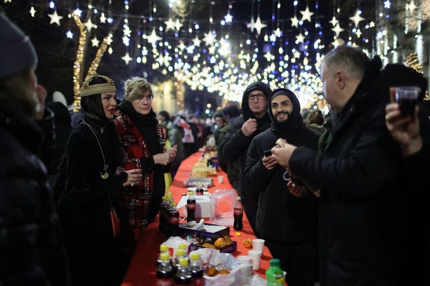 Georgians protest in Tblisi, with a long table and food and Coke bottles.